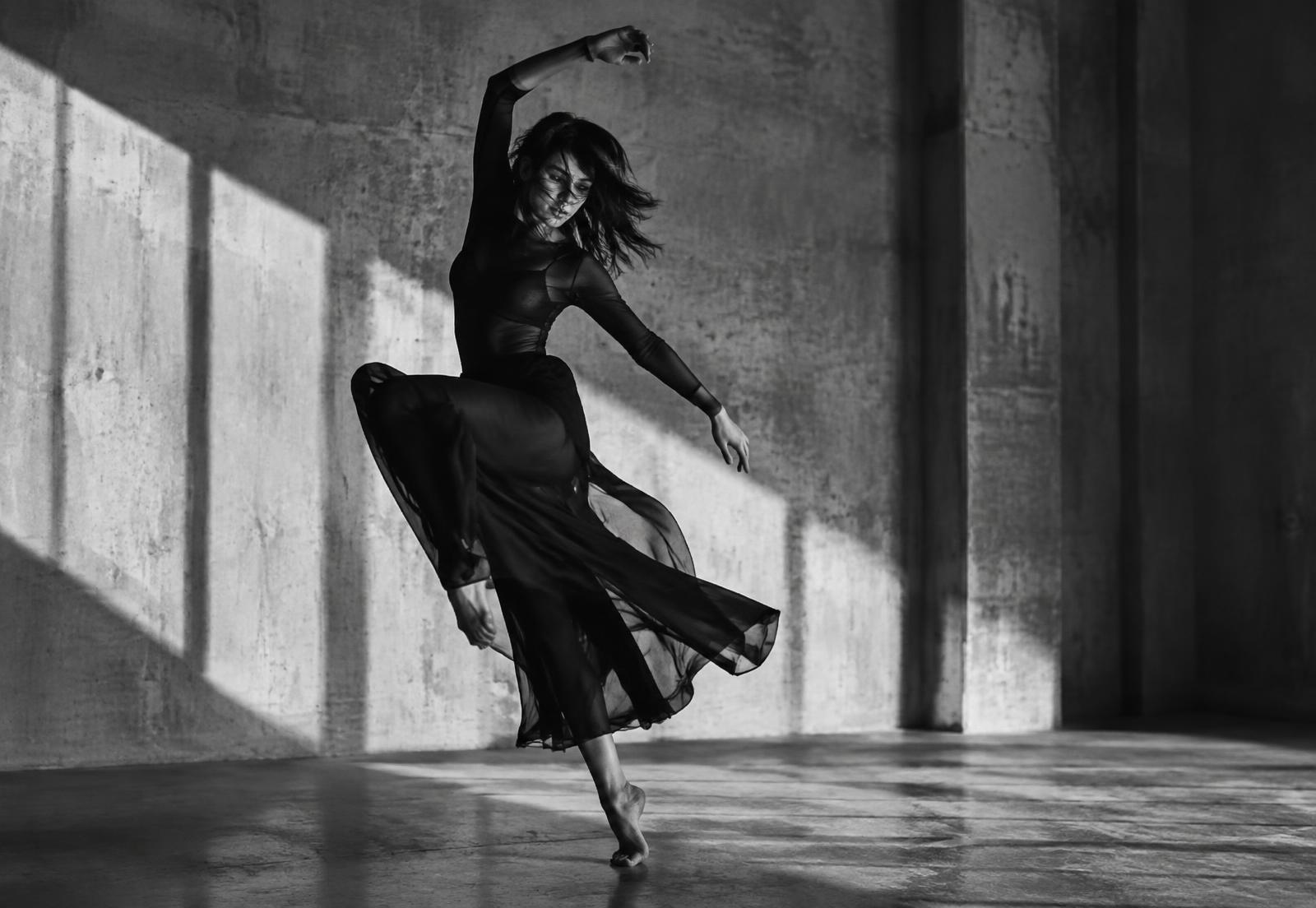 Dancer mid-movement in a concrete studio